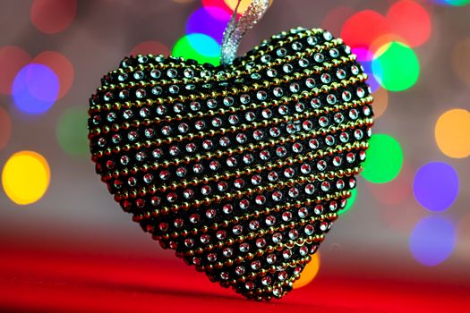 Heart shaped Christmas decoration isolated on blurred background of lights.