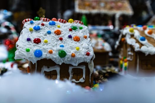 Colorful gingerbread house isolated on blurred background with Christmas decoration.