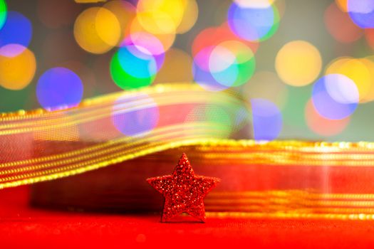 Red glittery decoration in a colorful Christmas composition isolated on background of blurred lights.