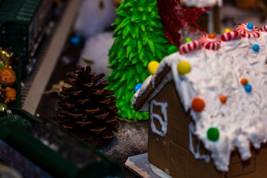 Colorful gingerbread house isolated on blurred background with Christmas decoration.