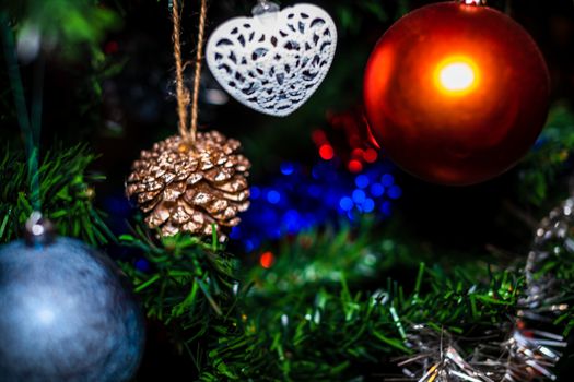 Christmas hanging decorations on fir tree. Decorated Christmas tree. Fir branch with Christmas baubles decorations.