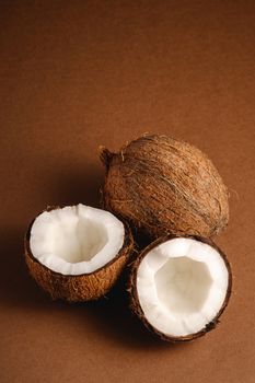 Coconut fruits on brown plain background, abstract food tropical concept, angle view