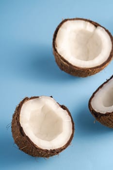 Coconut fruits on blue vibrant plain background, abstract food tropical concept, ange view macro