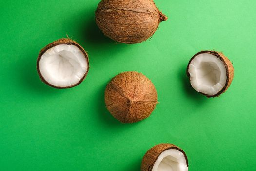 Coconut fruits on green plain background, abstract food tropical concept, top view