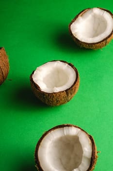 Coconut fruits on green plain background, abstract food tropical concept, angle view