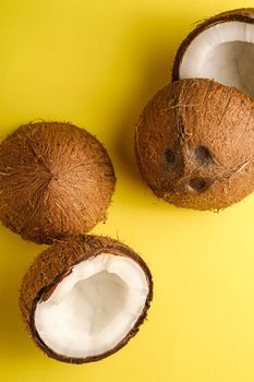 Coconut fruits on yellow plain background, abstract food tropical concept, top view macro