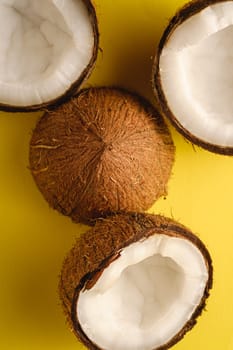 Coconut fruits on yellow plain background, abstract food tropical concept, top view macro