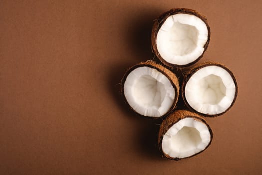 Coconut fruits on brown plain background, abstract food tropical concept, top view copy space