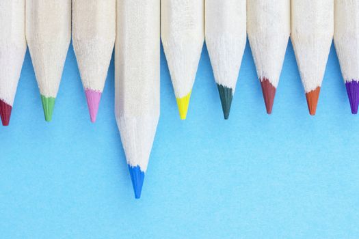 Multicolored pencils on blue background , wooden pencils with colored points in a row ,studio shot