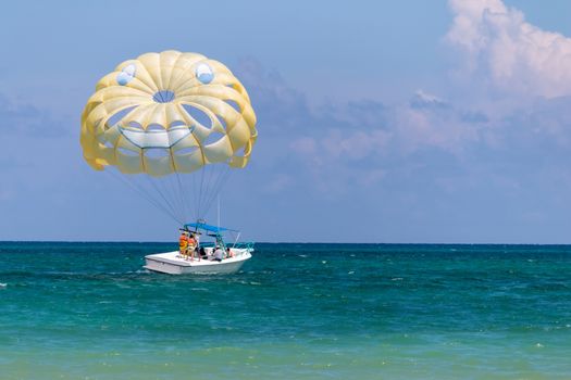 Yellow wing with happy face from skydiving pulled by a boat. Summer maritime recreation