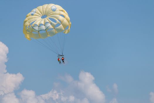 Yellow wing with happy face from skydiving pulled by a boat. Summer maritime recreation