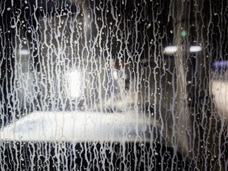 white water coolant emulsion streaming down on cnc machine polycarbonate window - closeup with selective focus