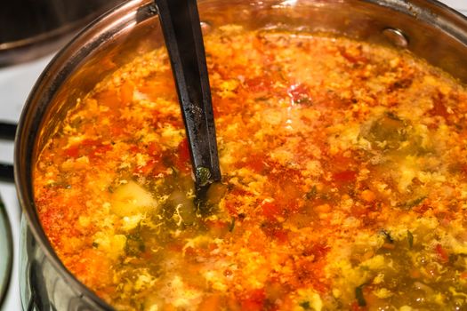 Preparation of soup with chicken and vegetables. Close up of boiling soup.