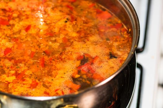 Preparation of soup with chicken and vegetables. Close up of boiling soup.