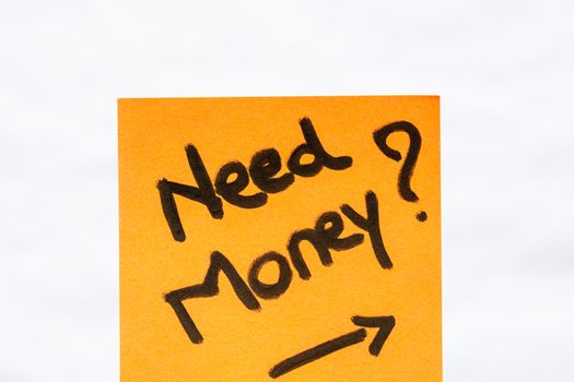 Need money handwriting text close up isolated on orange paper with copy space.