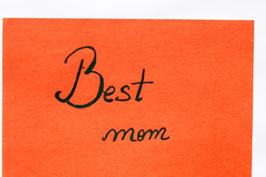 Best mom ever handwriting text close up isolated on orange paper with copy space. Writing text on memo post reminder