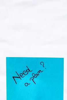Need a plan handwriting text close up isolated on blue paper with copy space. Writing text on memo post reminder