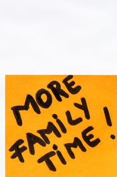 More family time handwriting text close up isolated on orange paper with copy space.