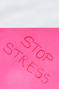 Stop stress handwriting text close up isolated on pink paper with copy space. Writing text on memo post reminder