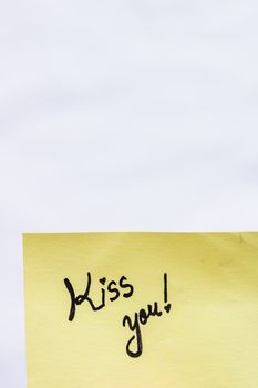 Kiss you handwriting text close up isolated on yellow paper with copy space.