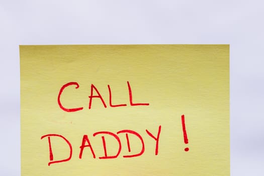 Call daddy handwriting text close up isolated on yellow paper with copy space.