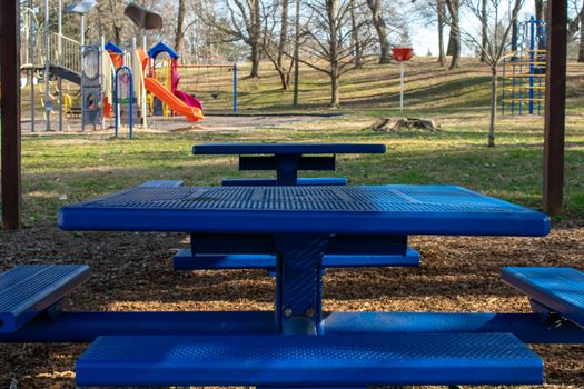 A Square Metal Blue Bench in a Park Underneath a Wooden Gazebo