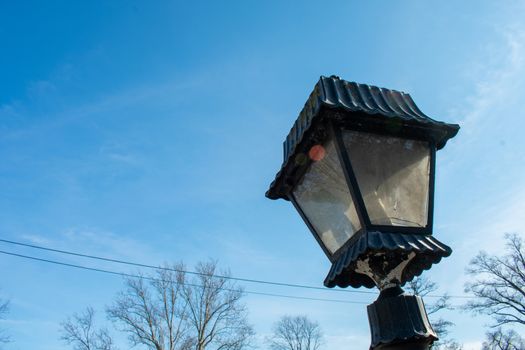 An Old-Fashioned Black Metal Lamp Post on a Clear Blue Sky