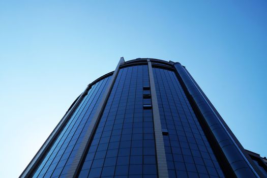 Varna, Bulgaria - August, 4, 2020: modern glass facade of a skyscraper against the backdrop of a sunny cloudy sky