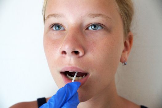 the doctor takes a test for coronavirus from the girl's mouth.