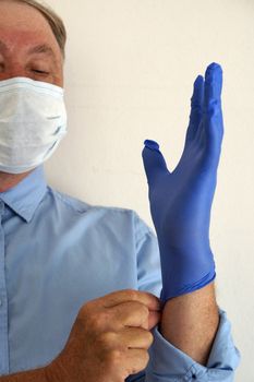 masked doctor puts on medical gloves close-up