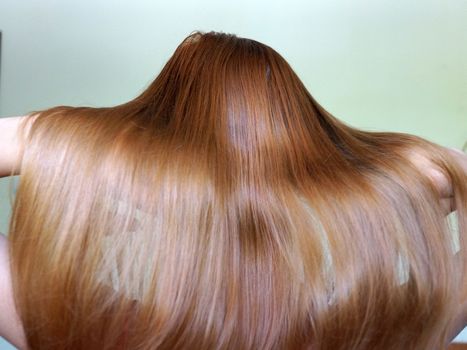 girl with long shiny blonde hair, back view close up