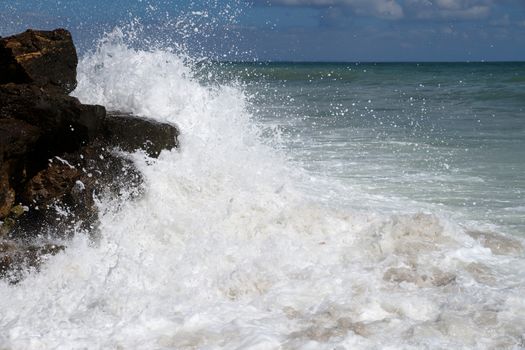 big white waves hitting the sea shore.