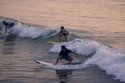 KOvalam, Tamilnadu- Indian, Oct 2, 2020. Foreign tourists floating on the Kovalam beach in Chennai amidst the waves of the sea, surfing