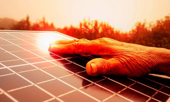 Close up of hand touching on solar panel outdoors.