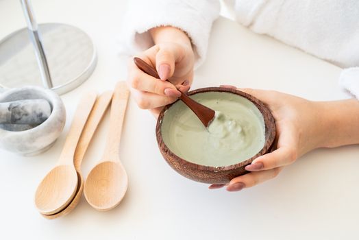 Spa and wellness. Natural cosmetics. Self care. Young caucasian woman wearing bathrobes doing spa procedures using natural cosmetics