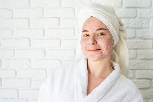 Spa and wellness. Natural cosmetics. Self care. Happy young woman applying face scrub on her face