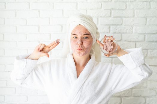 Spa and wellness. Natural cosmetics. Self care. Happy young woman applying face scrub on her face