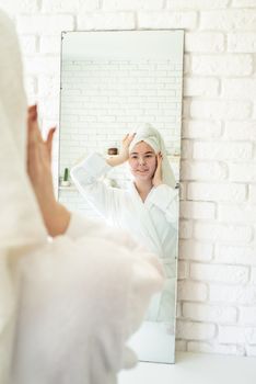 Spa and wellness. Natural cosmetics. Self care. Happy young woman applying face scrub on her face