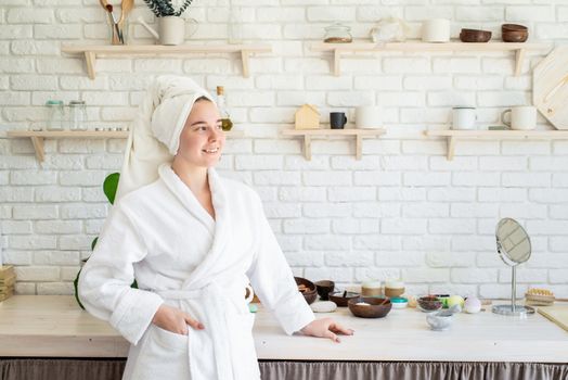 Spa and wellness. Natural cosmetics. Self care. Happy young woman applying face scrub on her face in her home kitchen