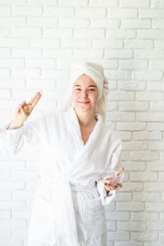 Spa and wellness. Natural cosmetics. Self care. Happy young woman applying face scrub on her face