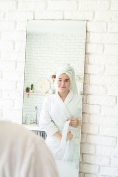 Spa and wellness. Natural cosmetics. Self care. Happy young woman applying face scrub on her face