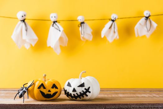 Funny Halloween day decoration party, Baby cute white ghost crafts scary face hanging and halloween pumpkin head jack lantern smile and spider on wooden, studio shot isolated, Happy holiday concept