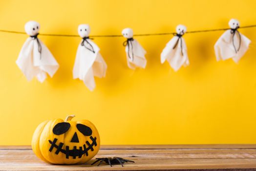 Funny Halloween day decoration party, Baby cute white ghost crafts scary face hanging and halloween pumpkin head jack lantern smile and spider on wooden, studio shot isolated, Happy holiday concept