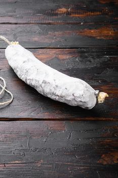 Spanish dry salchichon sausage on old wooden table.