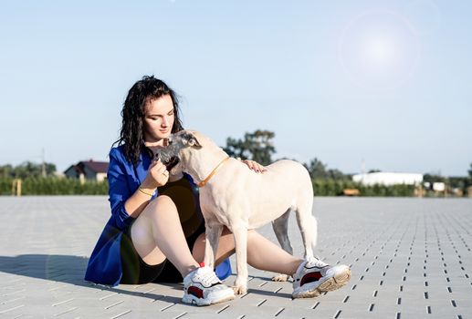 Pet care. Pet adoption. Young woman playing with her dog in the park