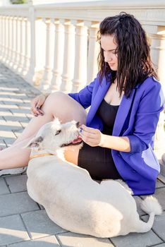 Pet care. Pet adoption. Young woman playing and hugging her dog in the park