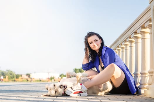 Pet care. Pet adoption. Young woman playing and hugging her dog in the park