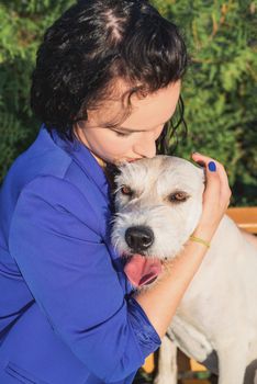 Pet care. Pet adoption. Young woman playing and hugging her dog in the park