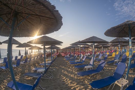 sunset beach with umbrellas and sunbeds without tourists