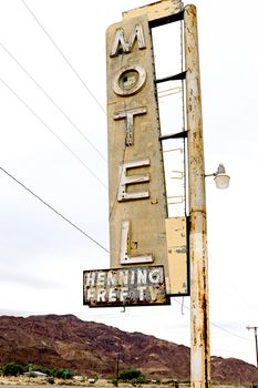 Old Motel sign ruin along historic Route 66 in the middle of California vast Mojave desert.